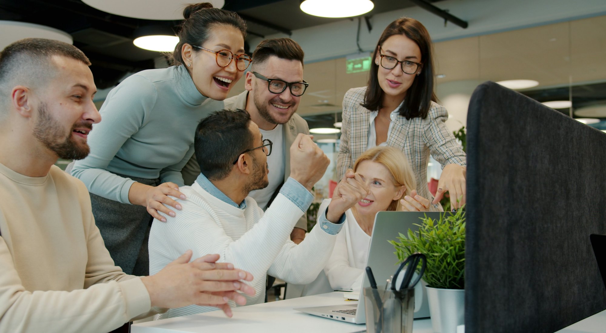 Une équipe se réjouit autour d’un écran, dans un bureau